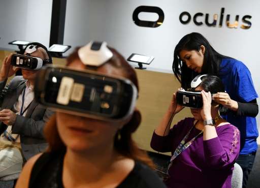 Gamers test a new virtual reality game headset at the Oculus display at the Electronic Entertainment Expo in Los Angeles, Califo