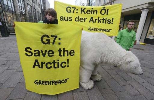 Greenpeace activists pose with a mockup of a polar bear and with banners reading &quot;G7: Save the Arctic!&quot; and &quot;G7: 