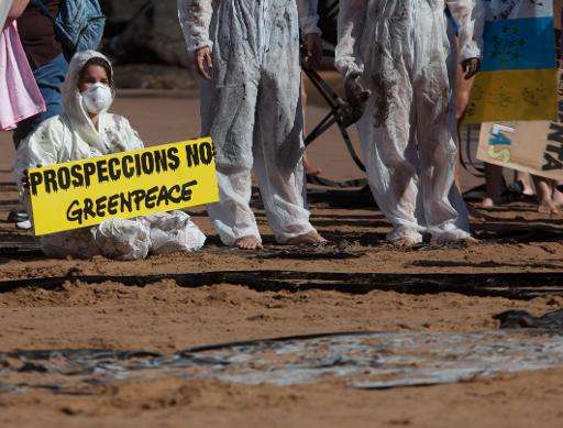 Greenpeace volunteers hold up a sign saying &quot;Prospecting, No&quot; north of Santa Cruz de Tenerife on June 28, 2014 during 
