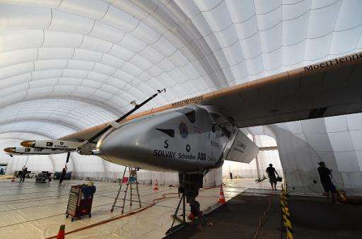 Ground crew work inside the mobile hanger of the solar-powered airplane Solar Impulse 2, at Nagoya airport in Japan, on June 3, 