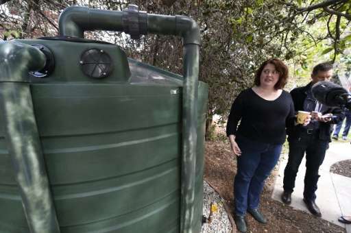 Homeowner Carrie Wassenaar, pictured November 4, 2015, shows off a new 1,320 gallon (5,000 liter) water tank designed to capture