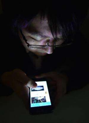 Japanese college student Masaki Shiratori surfs the Internet on his smartphone