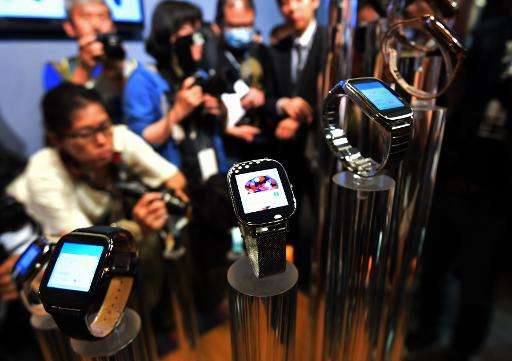 Journalists take photos of smart watches made by Taiwan's ASUSTeK Computer during the Computex trade show in Taipei, June 2, 201