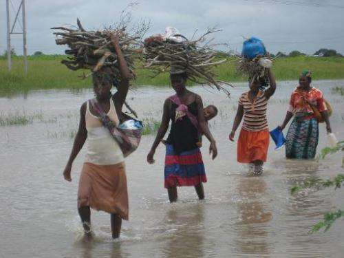 Local women wade through floodwater on the outskirts of Chokwe, near the Limpopo river, Mozambique, on January 26, 2011