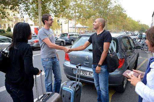 Michael (2nd left) says goodbye to people he has just brought to Lyon from Grenoble on September 5, 2012 under a car sharing sch