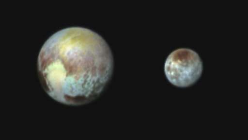 NASA image received July 14, 2015 shows an image of Pluto and Charon presented in false colors obtained by the Ralph instrument 