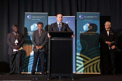 New Zealand's Prime Minister John Key (C) speaks to the press during the annual Pacific Islands Forum (PIF) summit, in Auckland,