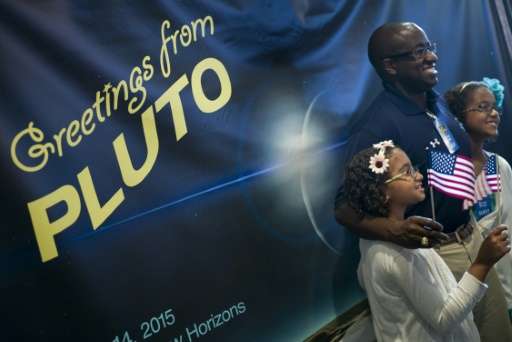 People pose for photos as they celebrate the closest fly-by of Pluto by the New Horizons probe at the Johns Hopkins University A