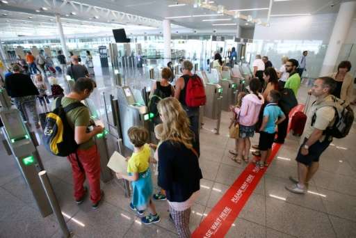 People wait to pass through new automated border control gates at Brussels Airport in Zaventem on August 3, 2015