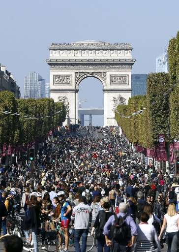 People walk and cycle along the Champs Elysee Avenue during the &quot;Car-Free Day&quot; event taking place in the French capita