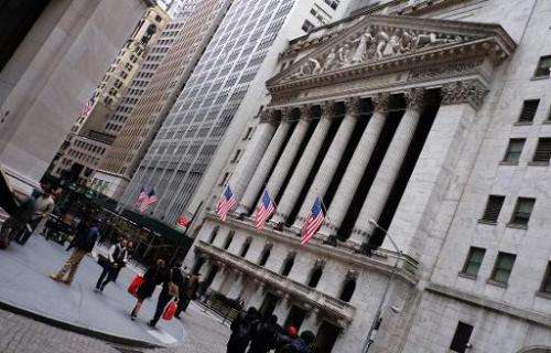 People walk past the New York Stock Exchange on January 20, 2105