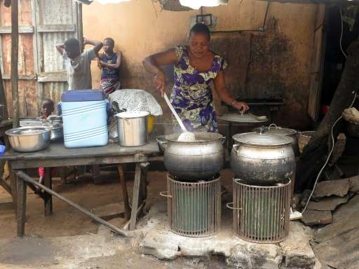 Philomene Ahouansou cooks beans and rice by the roadside using a solar-powered cooker in Porto-Novo, Benin