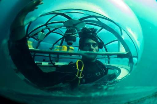 Project coordinator of Nemo's Garden, Gianni Fontanesi, checks condensation inside immerged Biosphere