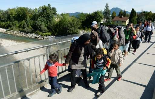 Refugees walk on a bridge crossing the border between Austria and Germany on their way from Salzburg to the Bavarian village of 