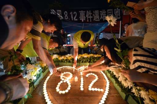 Residents lighting candles at the crossroads outside Tianjin Taida hospital at a vigil for the victims of the explosions at a ch
