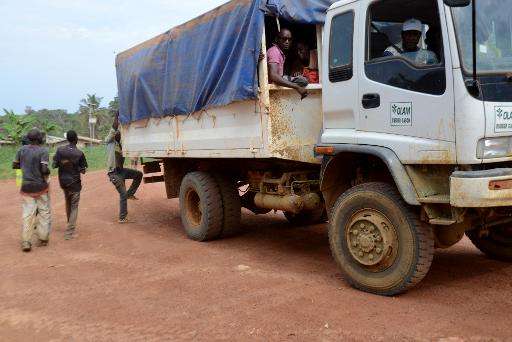 Rubber plantation workers board a truck at the Olam factory in Batouri, at the end of their working day