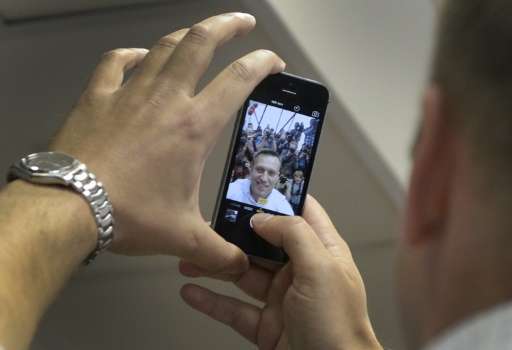 Russian opposition leader Alexei Navalny takes a selfie photograph with the media during a hearing at Moscow's Lyublinsky distri