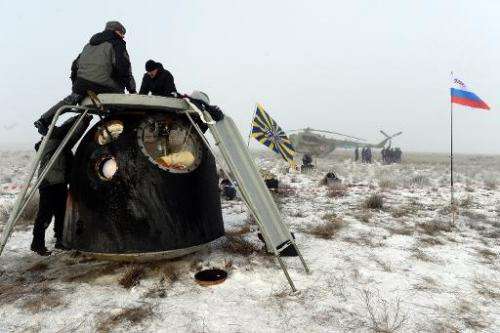 Russia's space agency ground personnel check Soyuz TMA-14M capsule shortly after the landing in a remote area outside the town o