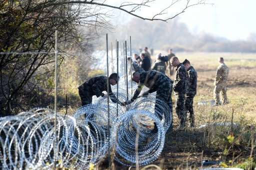 Slovenian soldiers set barbed wire fences on the Slovenian-Croatian border near Rakovec on November 12, 2015