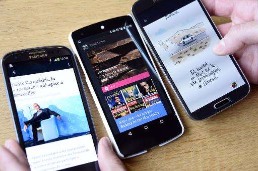 Smartphones displaying French daily newspaper Le Monde's new smartphone application on May 11, 2015