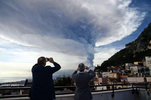 Smoke rises over the city of Taormina during an eruption of Mount Etna on December 4, 2015