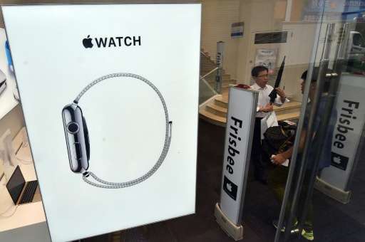 South Korean customers walk past a signboard of the &quot;Apple Watch&quot; at an Apple shop in Seoul on June 26, 2015