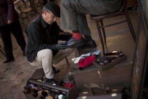 Spanish shoeshiner Javier Castano shines shoes on February 16, 2015 in Malaga, Spain