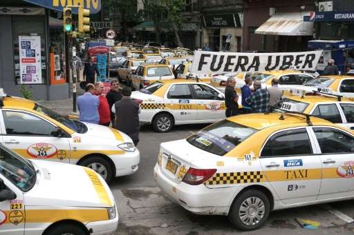 Taxi drivers block the street in front of the hotel where U.S. company Uber is training drivers, in Montevideo, on November 13, 