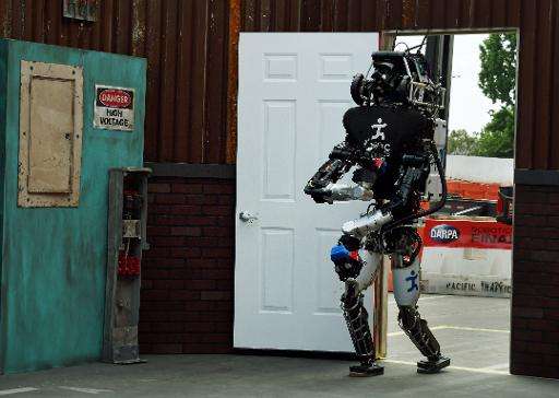 The robot named 'Running Man' developed by Team IHMC Robotics successfully opens a door during the finals of the DARPA Robotics 