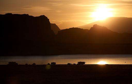 The sun rises over campers at Lake Powell's Lone Rock Camp on March 30, 2015 near Big Water, Utah