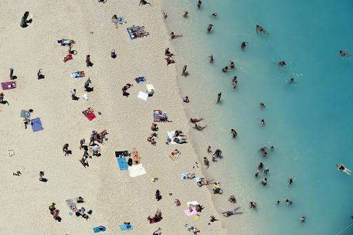 Tourists enjoy the sunshine and the sea at a beach on Zakynthos island, Greece, on June 23, 2014