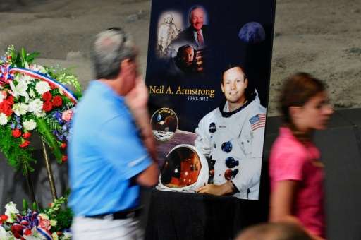 Tourists pass a poster and flowers in honor of former NASA astronaut Neil Armstrong at the Apollo/Saturn V Center, August 31, 20