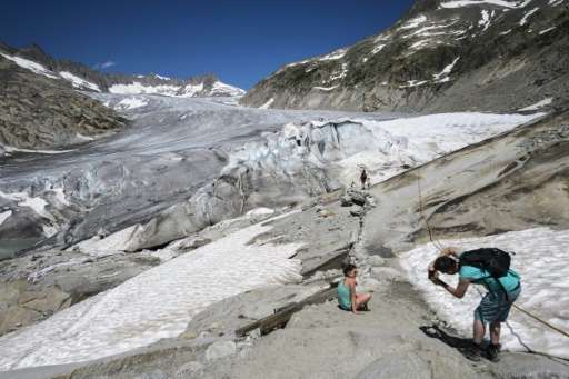 Tourists pose on the Rhone Glacier near Gletsch