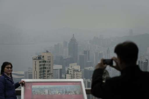 Tourists take pictures of haze over Hong Kong on January 9, 2014