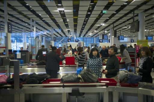 Travellers wait for security check at the Charles de Gaulle airport on December 31, 2012 in Roissy