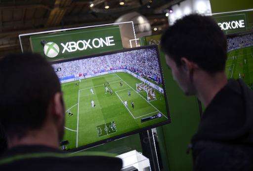 Visitors play on a Xbox One as they attend the Paris Games week show on October 29, 2014