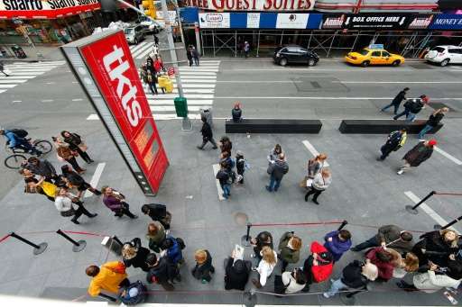 Visitors stand in line to purchase tickets to Broadway Shows in Times Square on October 31, 2012 in New York