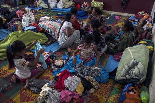 Women and children rest in an evacuation shelter set up following an eruption at Mount Sinabung in Kabanjahe village, in Karo di