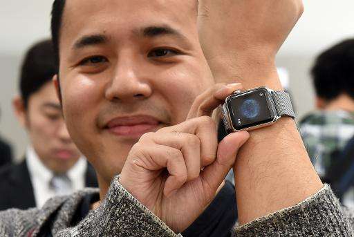 Yuichiro Masui, the first Apple Watch customer at a telecom shop in Tokyo's Omotesando area, poses with his new purchase on Apri
