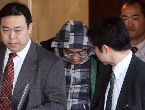 Yusuke Katayama, 30, (C) is arrested by police in Tokyo, on February 10, 2013