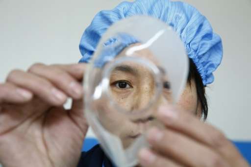 A worker checks a part for pollution mask at the ASL Masks factory in Dongliu, China's Shandong province