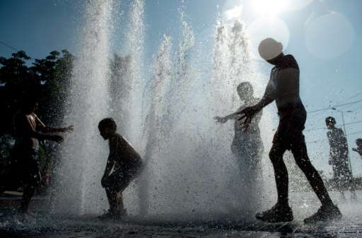 Children play in a fountain during a hot summer day in Santiago, Chile on February 2, 2016