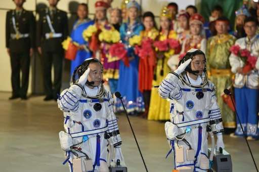 Chinese astronauts Jing Haipeng (L) and Chen Dong, pictured at their send-off ceremony, spent 33-days orbiting the earth carryin