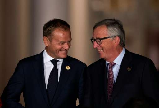 European Council President Donald Tusk (L) talks with President of the European Commission Jean-Claude Juncker as they walk acro