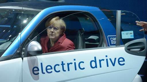 German Chancellor Angela Merkel sits in an electric car at the Daimler subsidiary car2go booth at the 2013 Frankfurt car show