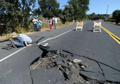 Local resident inspects a buckled highway outside of Napa, California, after earthquake struck the area in the early hours of Au