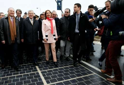 Segolene Royal and other officials walk on a solar panel road at its inauguration in Tourouvre, on December 22, 2016