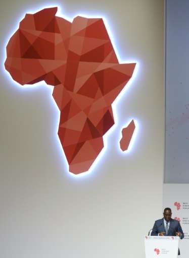 Senegal President Macky Sall (R) delivers a speech under a map of Africa in Dakar during the opening of the &quot;Next Einstein 