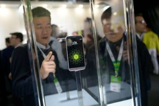 Visitors look at the new LG G5 model after its presentation on the eve of the official start of the Mobile World Congress in Bar