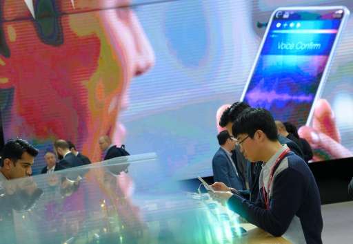 Visitors test smartphones during the Mobile World Congress in Barcelona on February 23, 2016